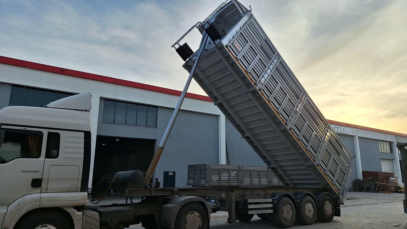 Gün batımında çekiciye bağlı damperli yarı römork ve arkada ikinci römork