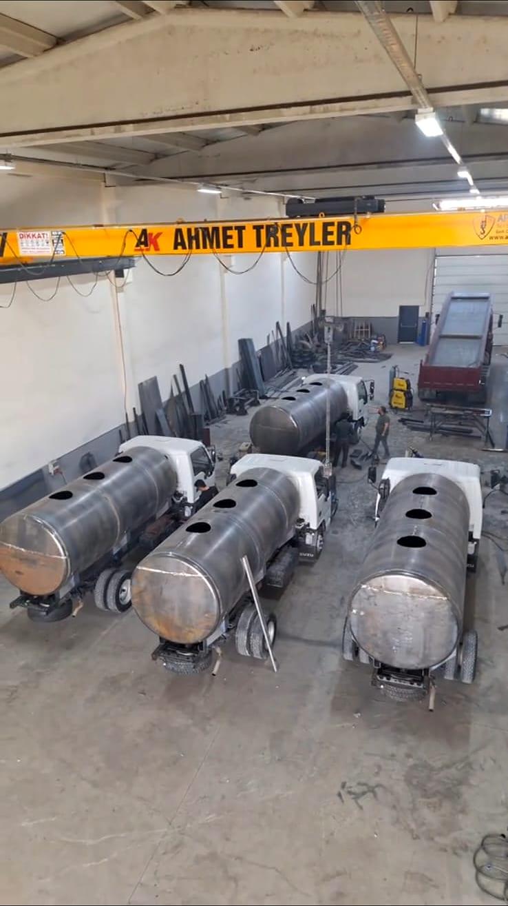 Ahmet Treyler atölyesinde üretim hâlindeki dört kamyon üstü tanker gövdesi ve tavandaki markalı vinç kirişi