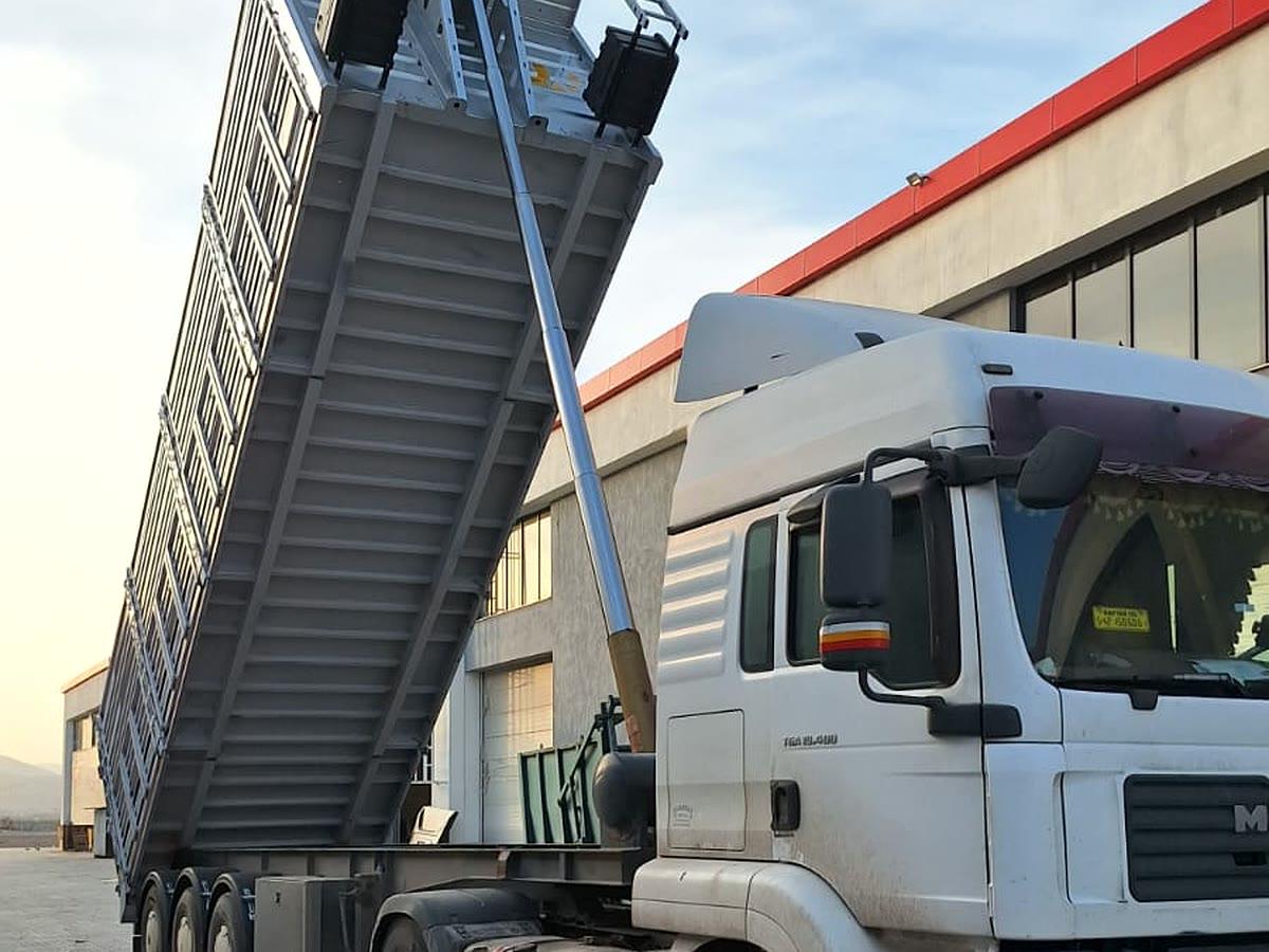 Çekiciye bağlı damperli yarı römork, kasası kaldırılmış hâlde yandan görünüm